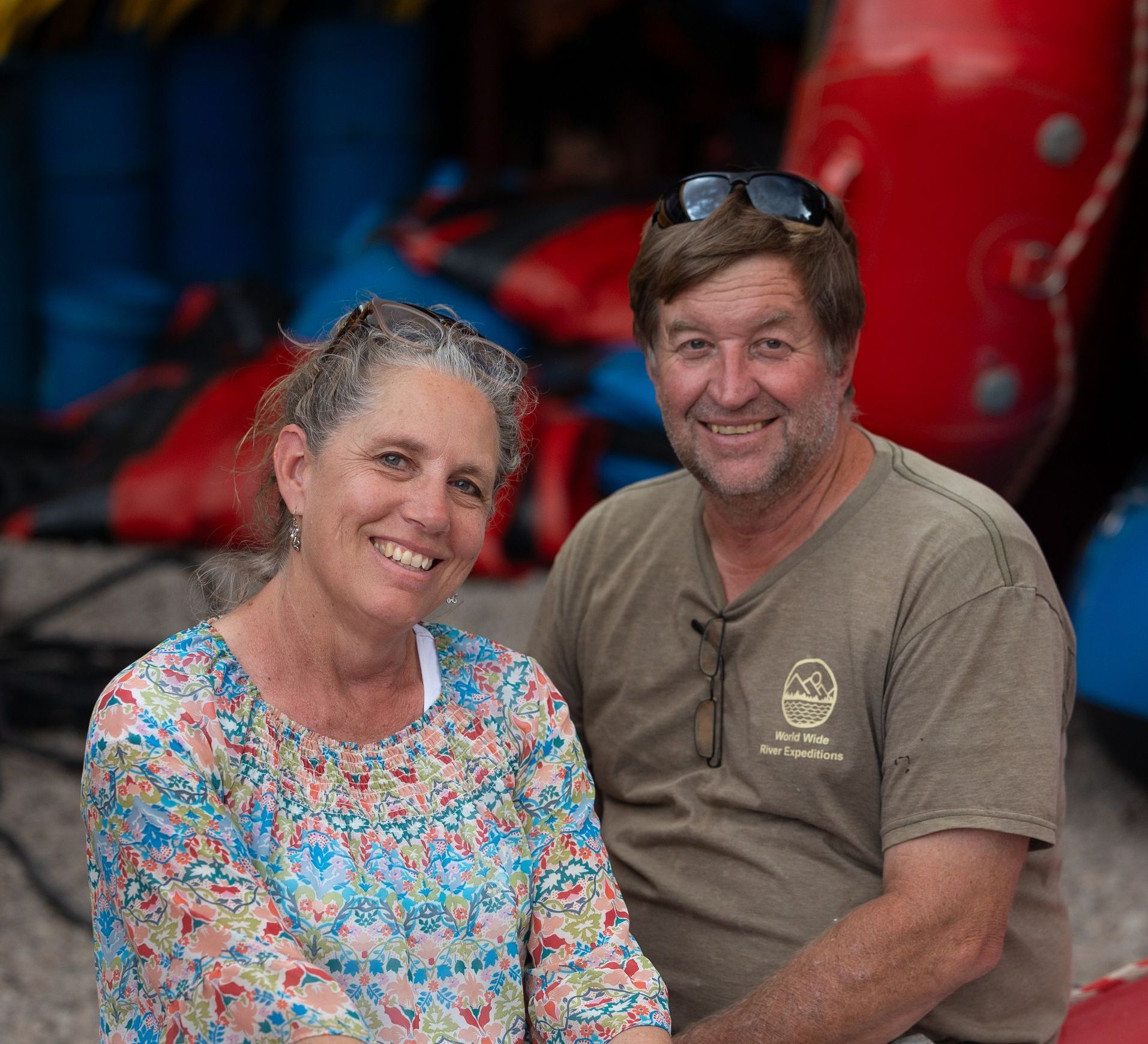 A man and a woman are posing for a picture in front of a mountain.