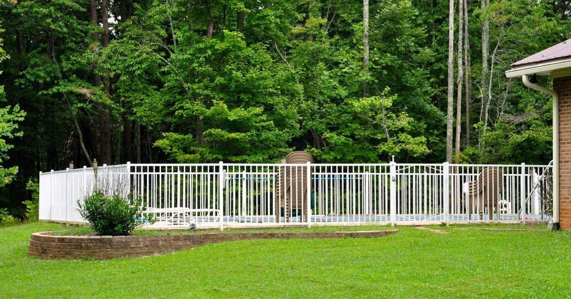 White aluminum fencing enclosing swimming pool