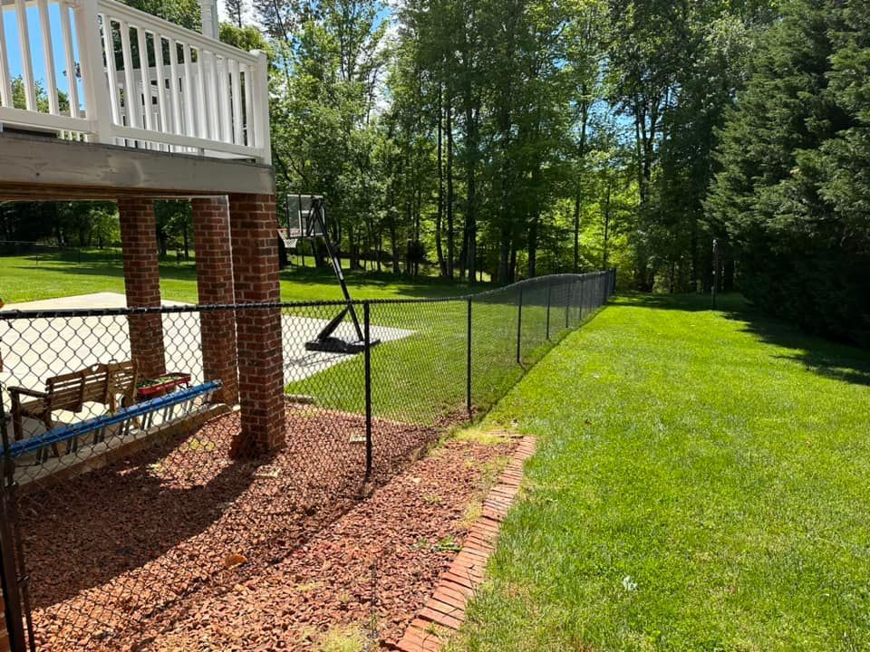 Black vinyl-coated chain link fencing enclosing backyard