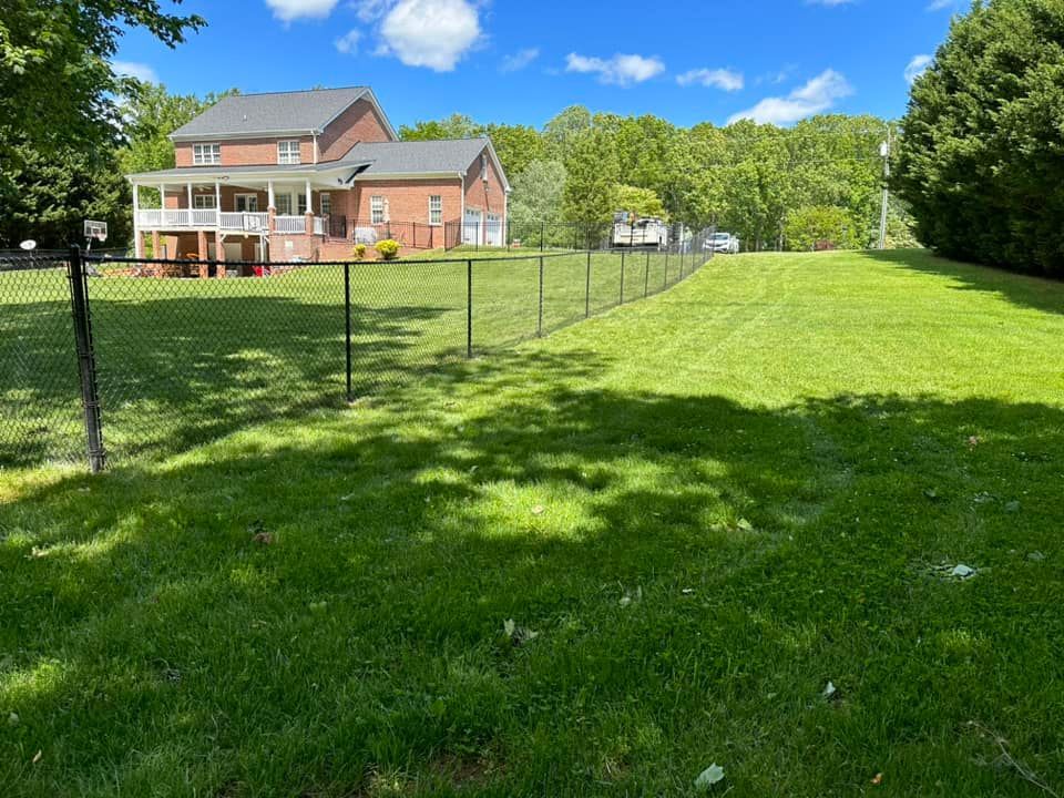 Black vinyl-coated chain link fencing enclosing property