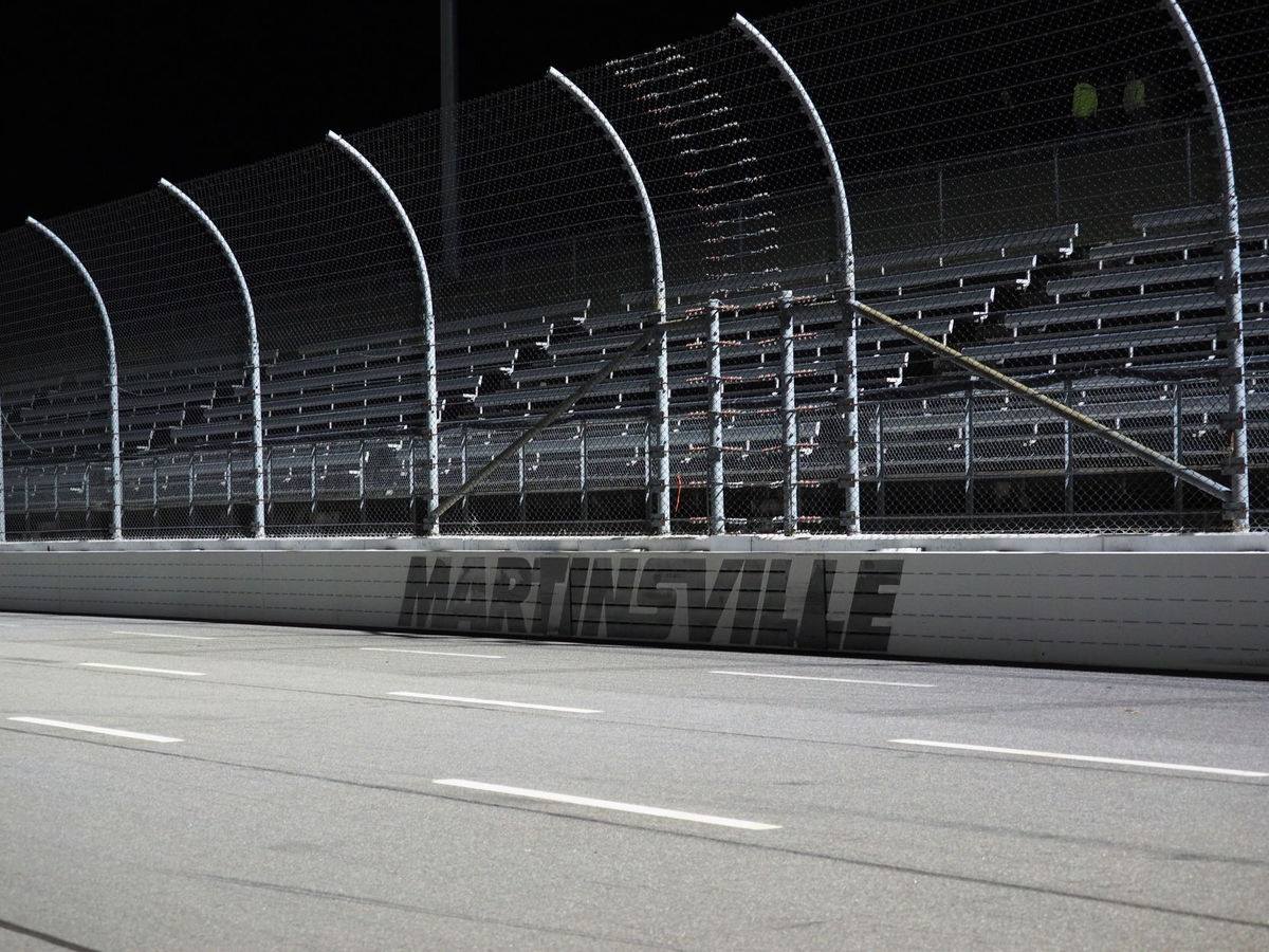 Side of race track with wall and chain link fence