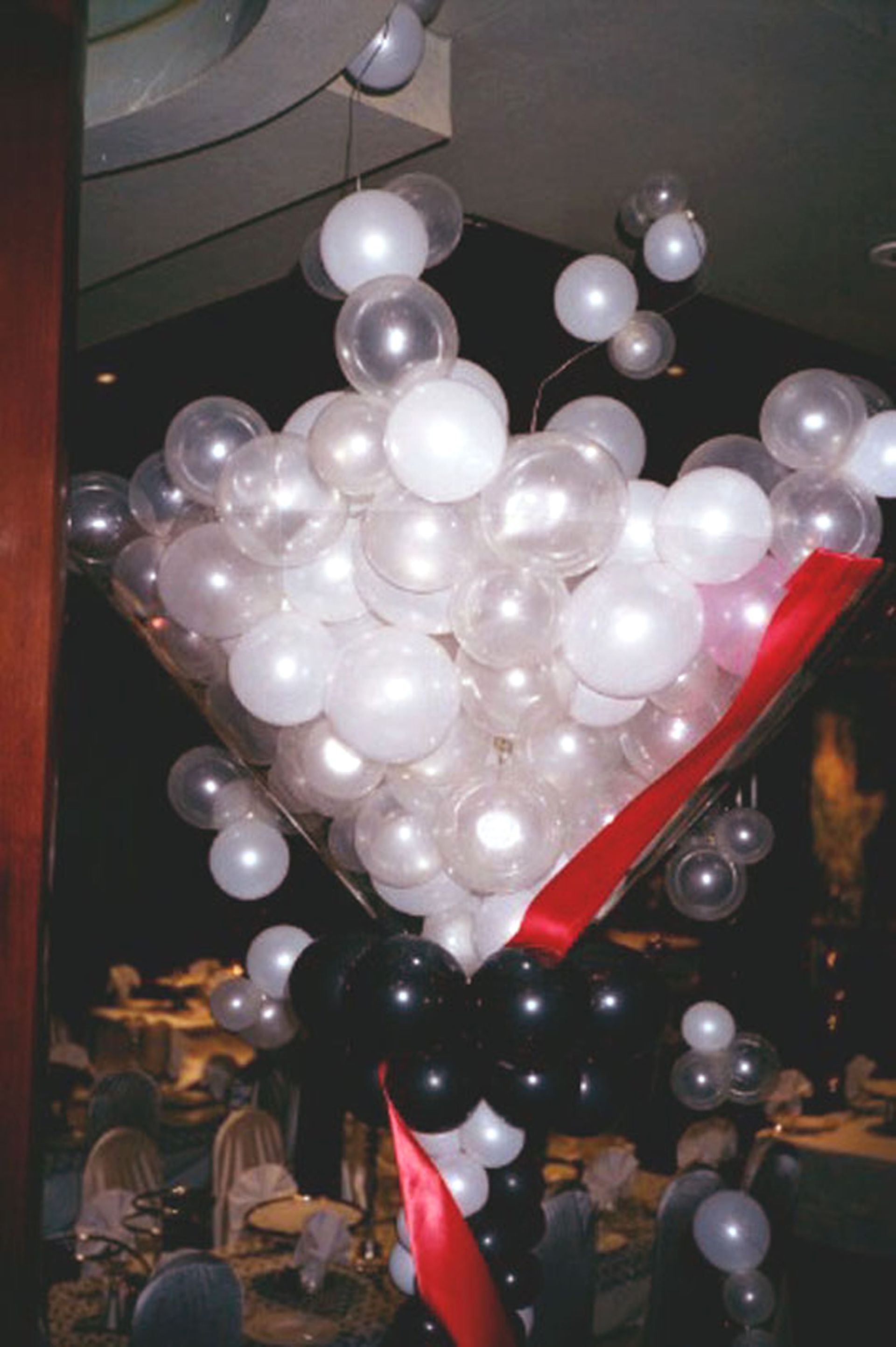 Martini glass balloon sculpture; clear and white balloons, black base, red ribbon.
