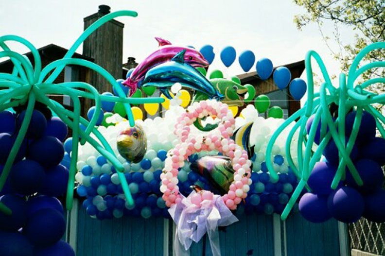 Balloon arch with dolphins, sea creatures, and blue and purple balloons.