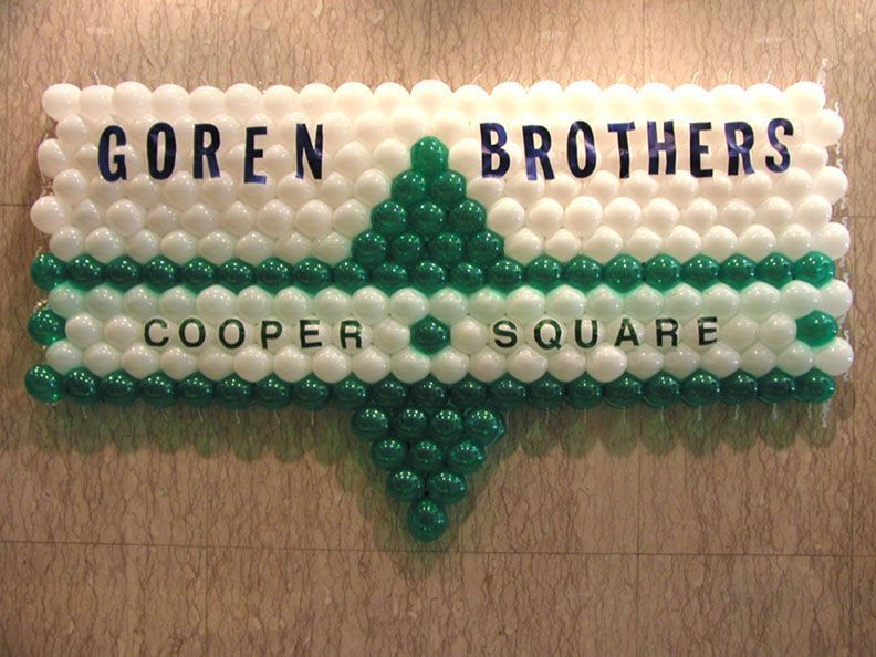 Sign made of white and green balloons that reads 