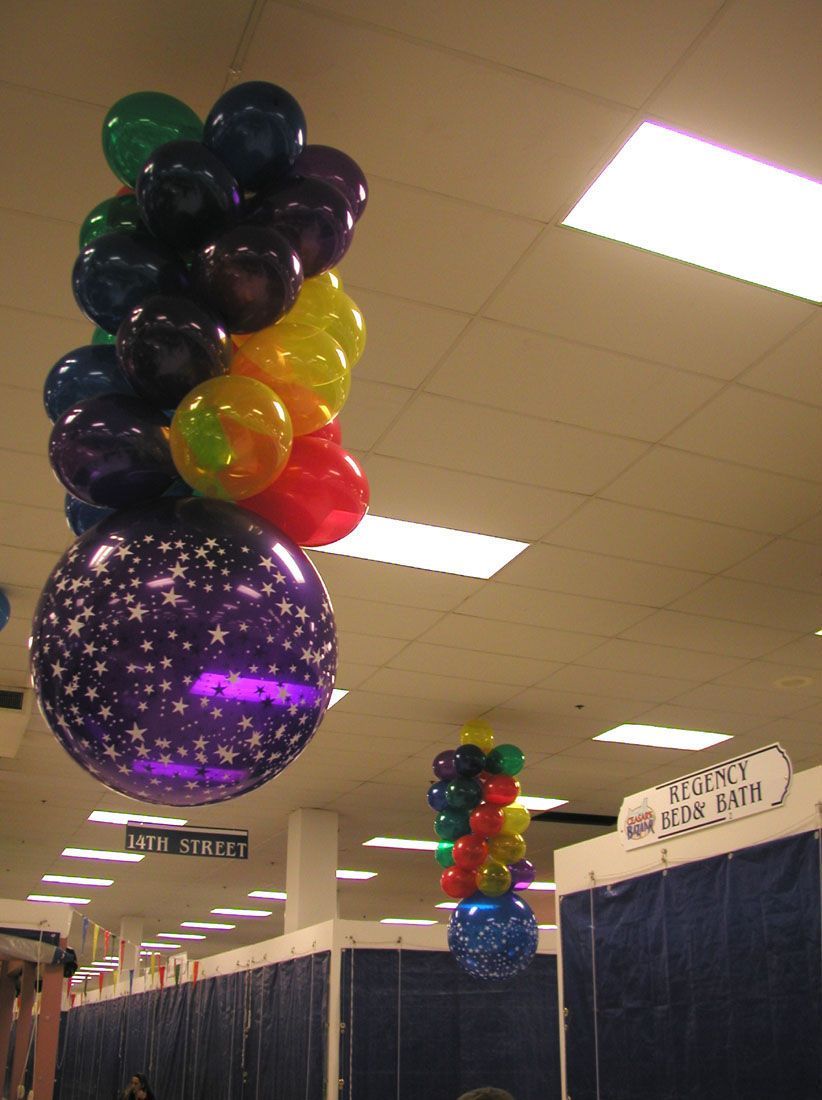 Balloon decorations in a room, featuring clusters of colorful balloons and a starry purple balloon.