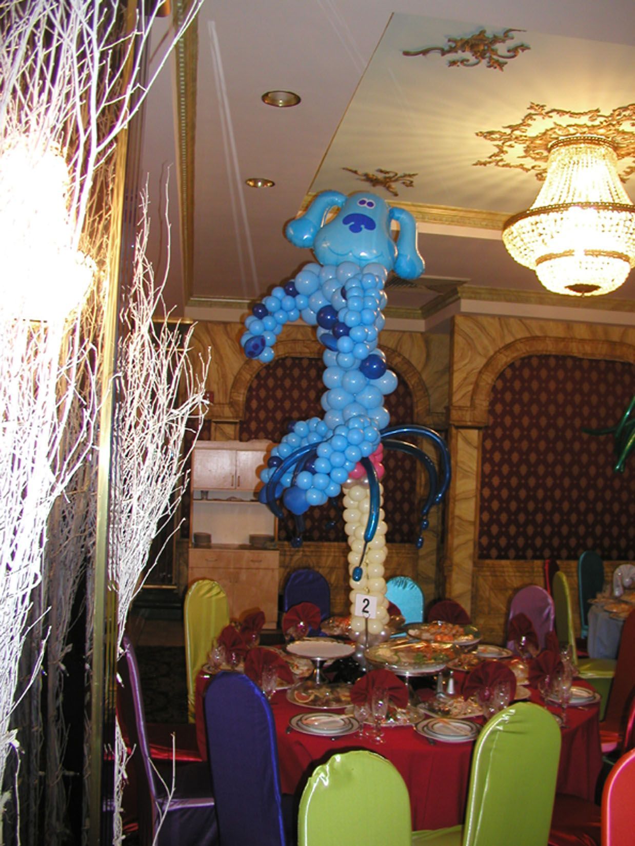 Blue's Clues balloon sculpture centerpiece on a table with food at a party.