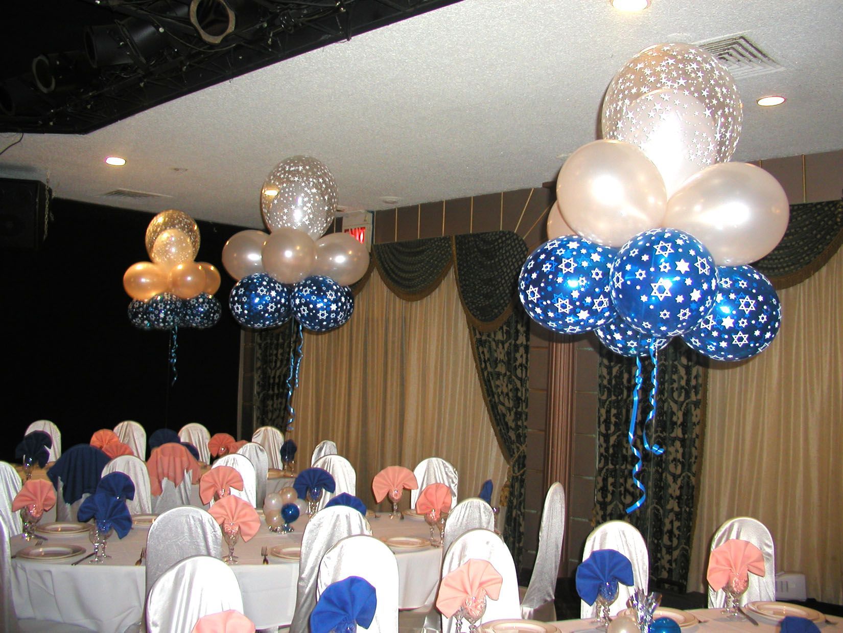 Decorated banquet tables with balloon centerpieces in a well-lit room.