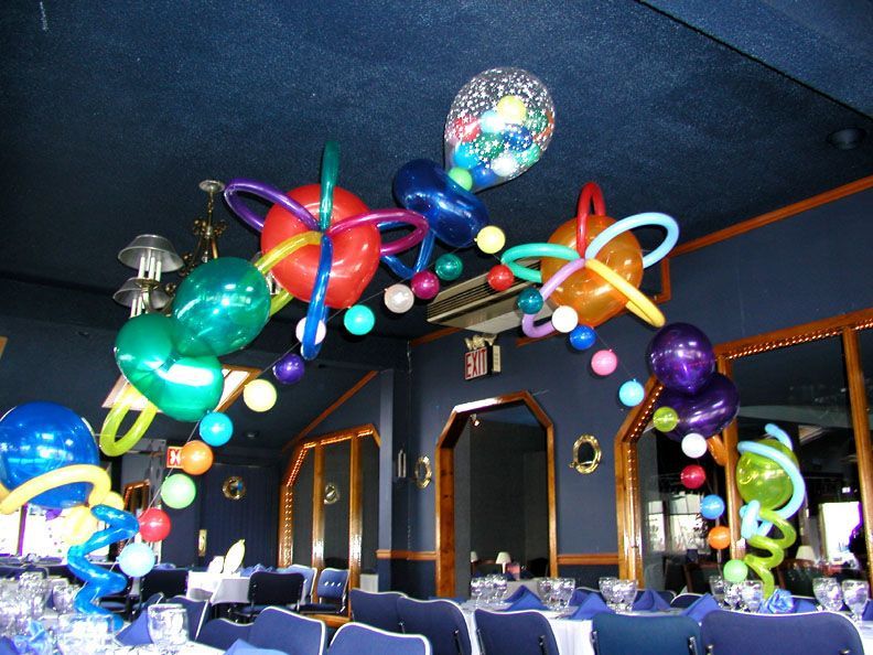 Balloon arch over a dining table, featuring colorful balloons of various shapes and sizes in a restaurant.