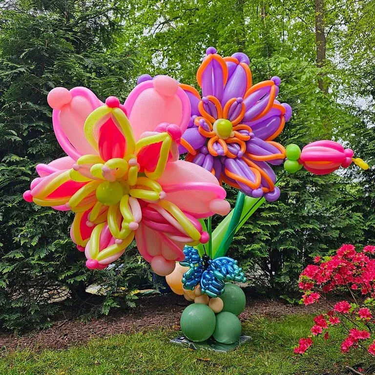 Colorful balloon flowers in a garden setting, including pink, purple, green, and orange.
