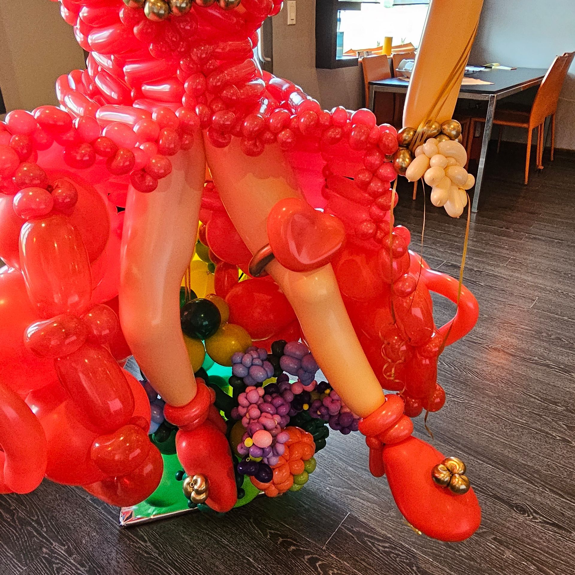 Red balloon sculpture of a person's legs, wearing red shoes.
