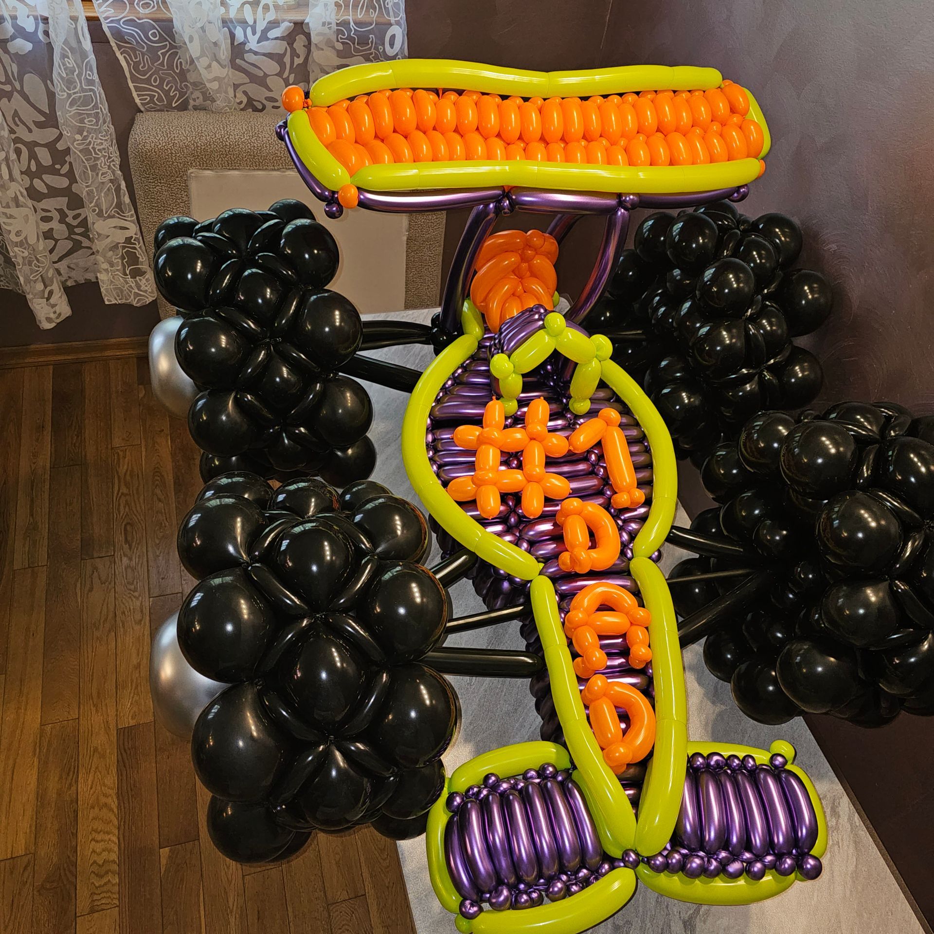 Balloon sculpture of a car that says #1 Dad, with black and purple accents.
