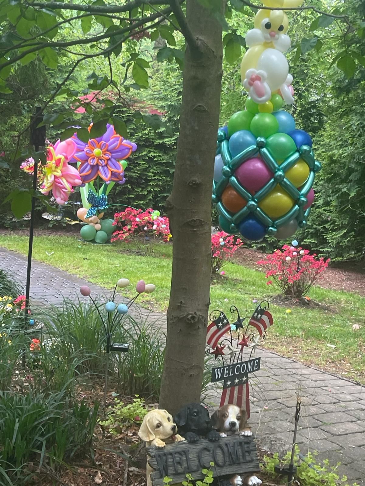 Easter decorations on a tree: balloon egg with a chick on top, and other lawn decorations.