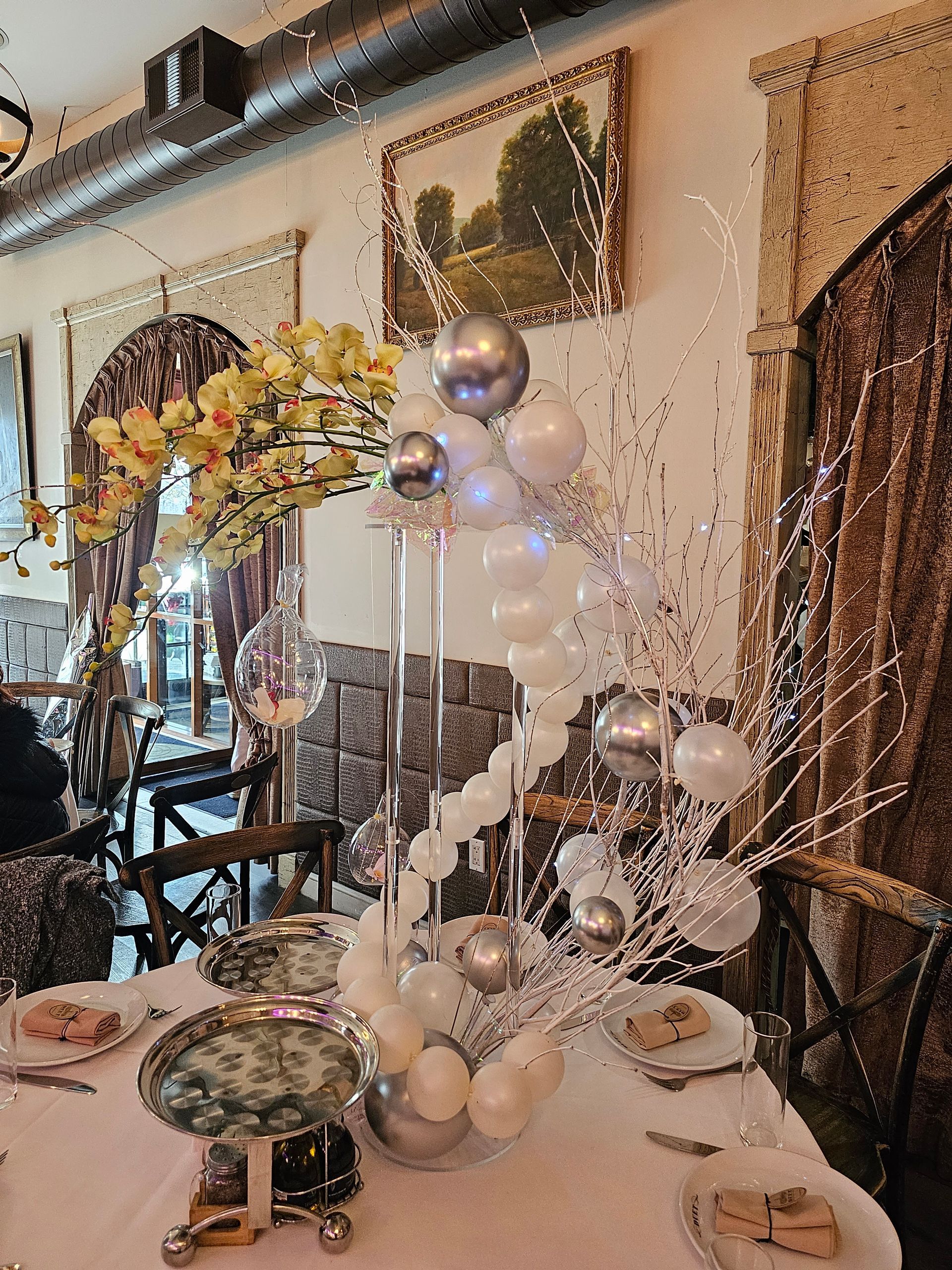 Table setting with floral and balloon centerpiece in a restaurant.