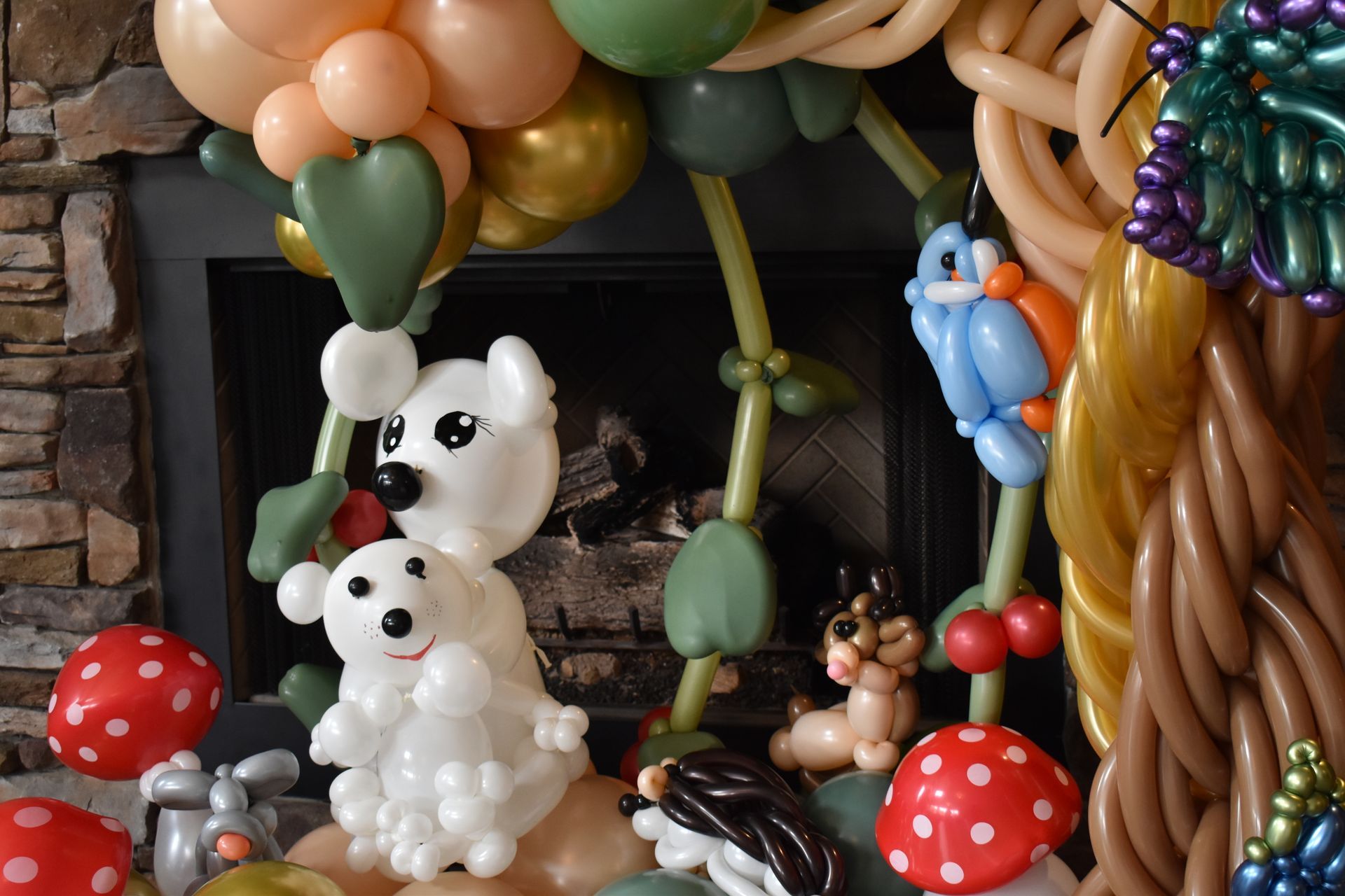 Balloon animal forest scene with polar bears, deer, mushrooms, and a butterfly.