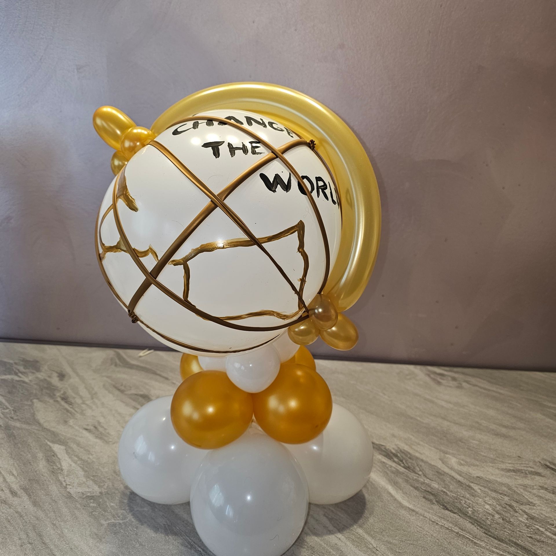 Balloon globe sculpture in gold and white with 