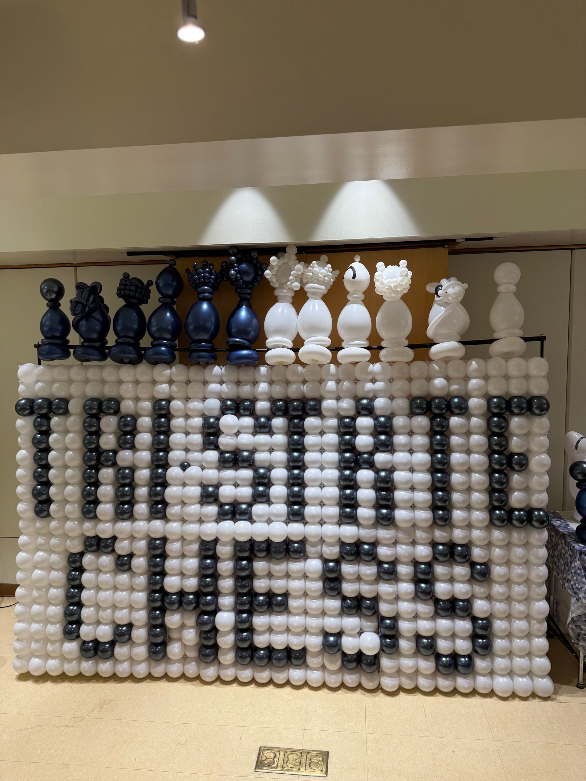 Chess pieces atop a balloon display that spells 