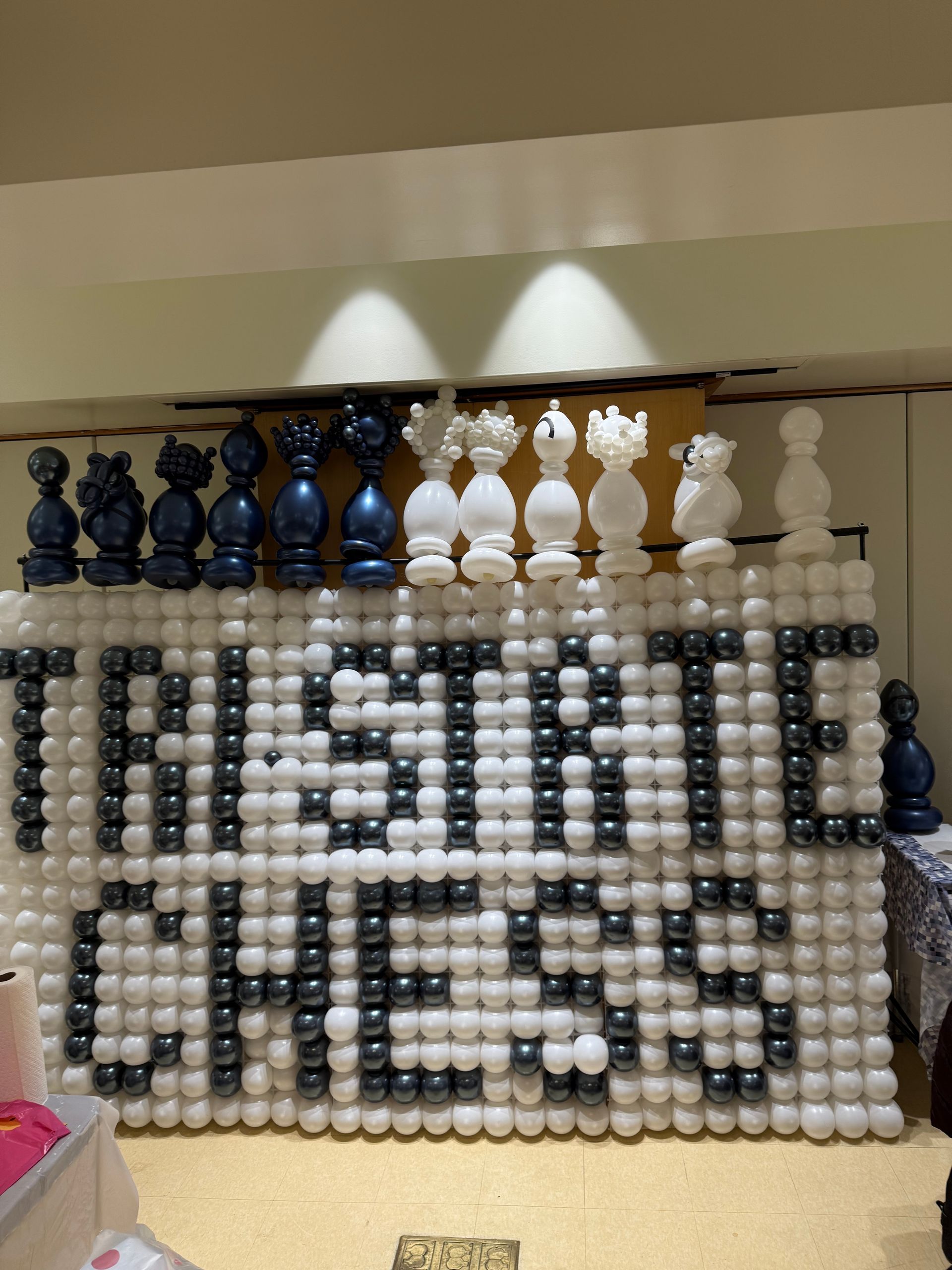 A chess set with blue and white pieces atop a sign spelling 