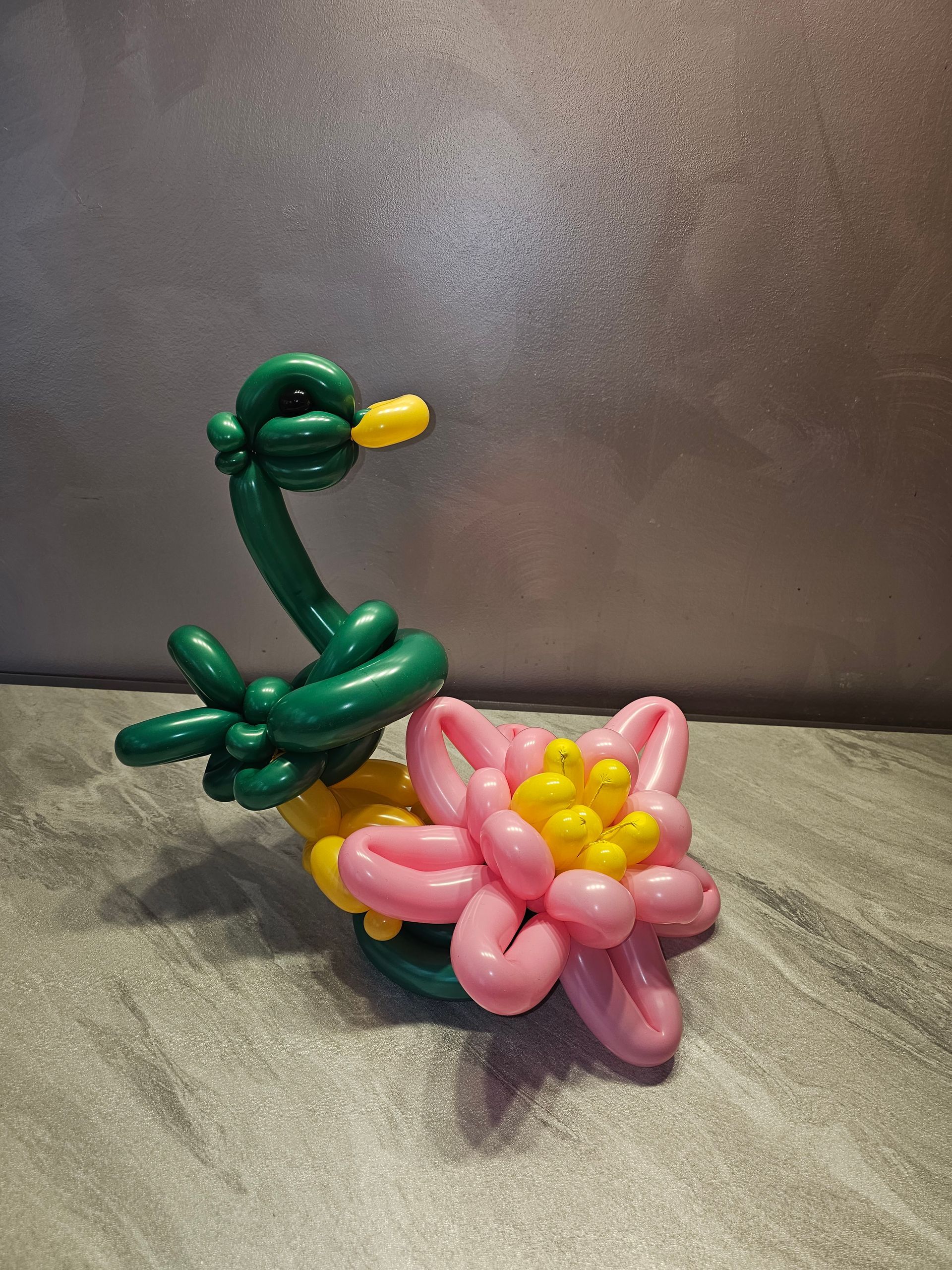 Green and yellow balloon duck with a pink and yellow balloon flower.