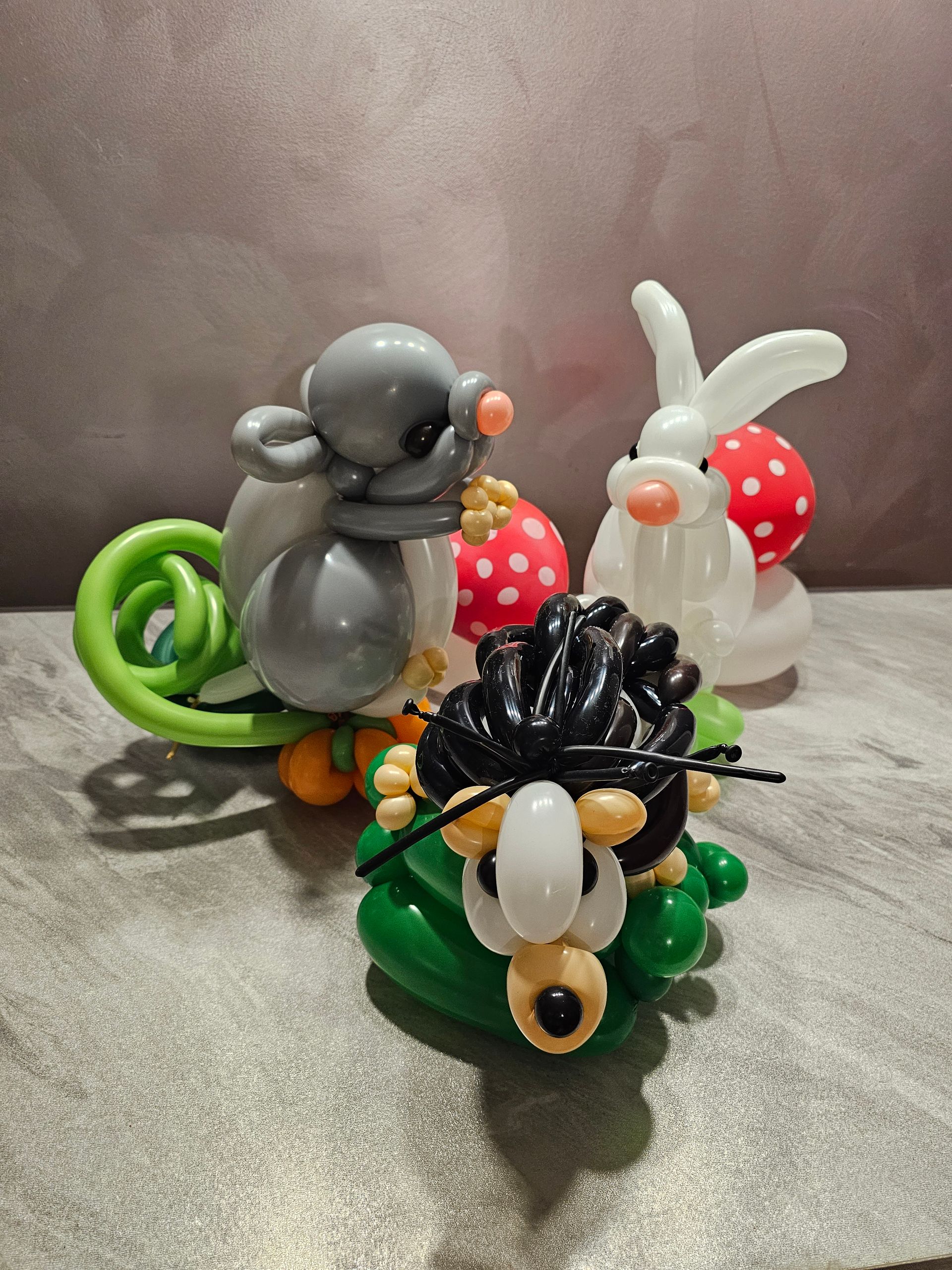 Balloon animals: mouse, hedgehog, and bunny with polka dot eggs.