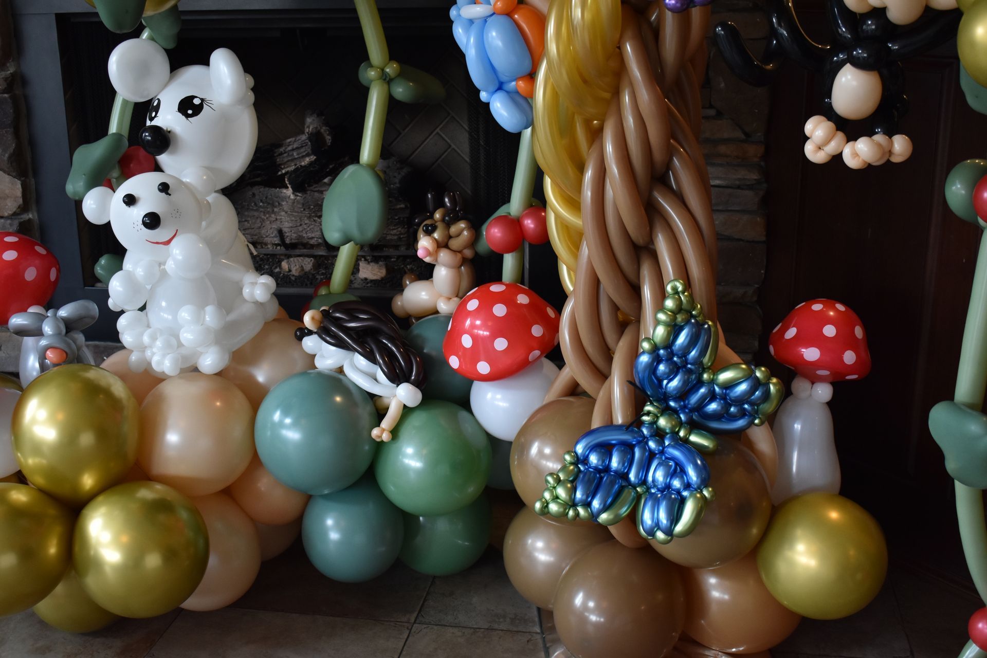 Balloon forest with animals, mushrooms, and butterfly, made of colorful balloons.