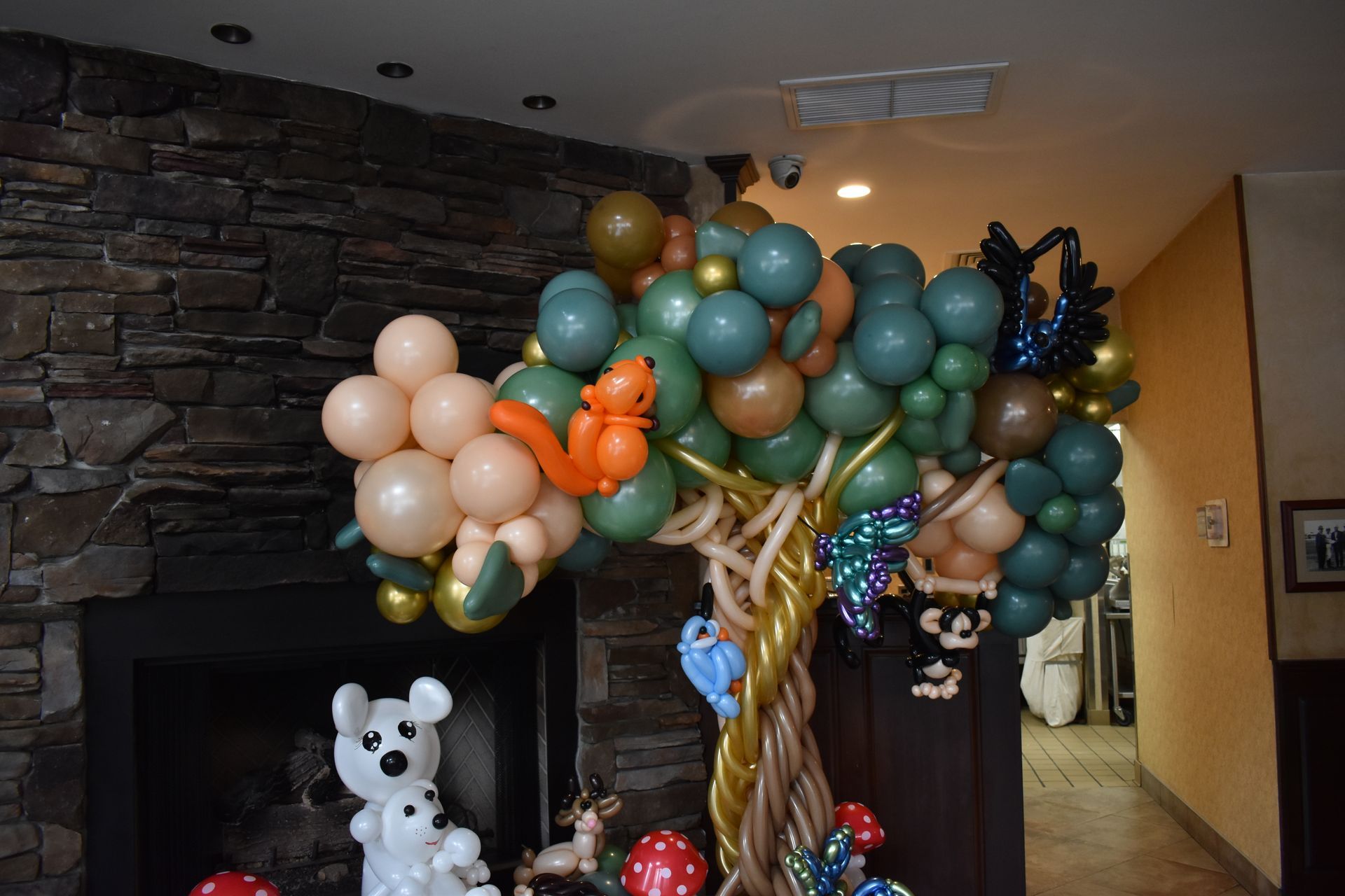 Balloon tree sculpture with squirrel, deer, and mouse figures.