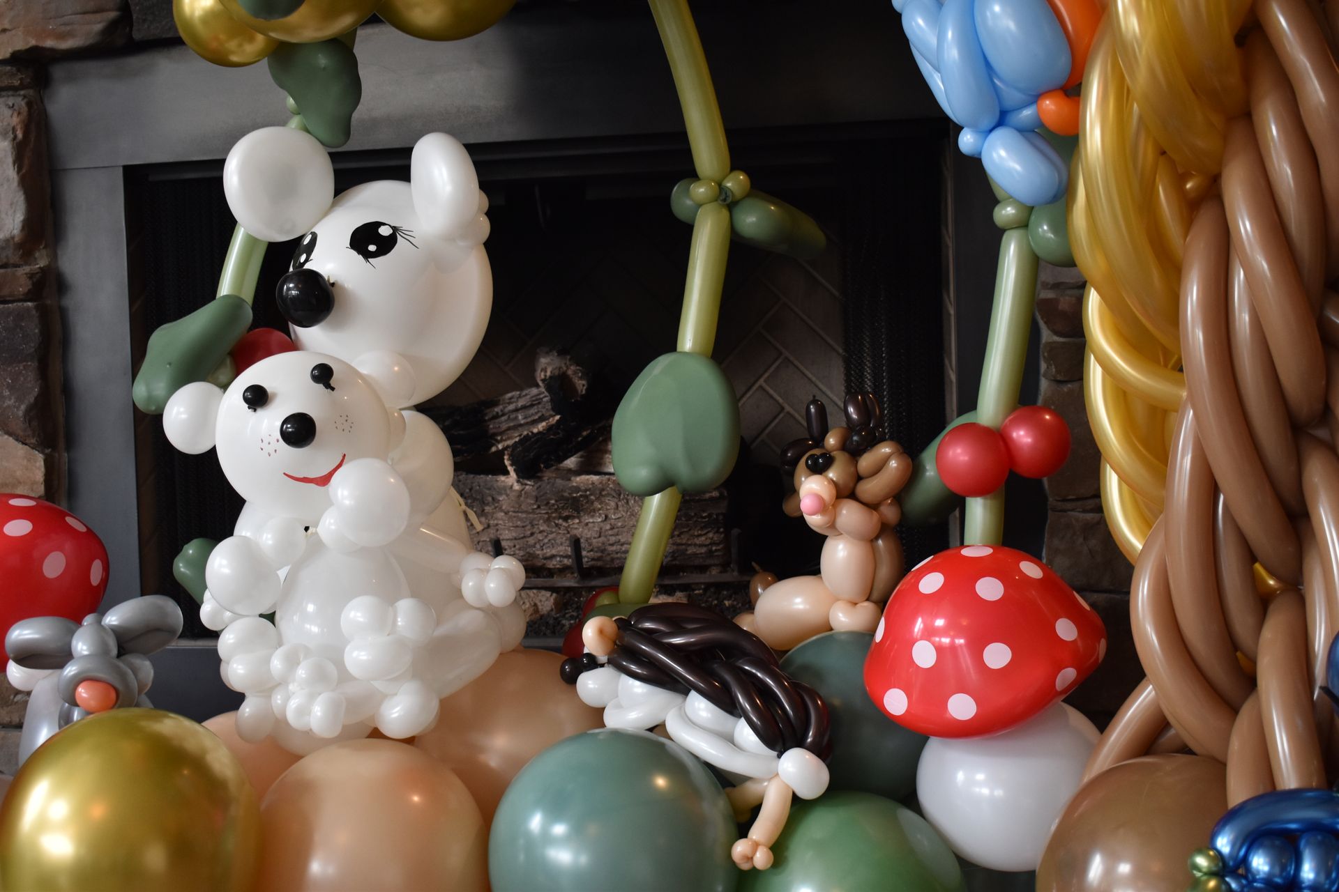 Balloon animals of a dog, deer, mushrooms, and other creatures on a stand.