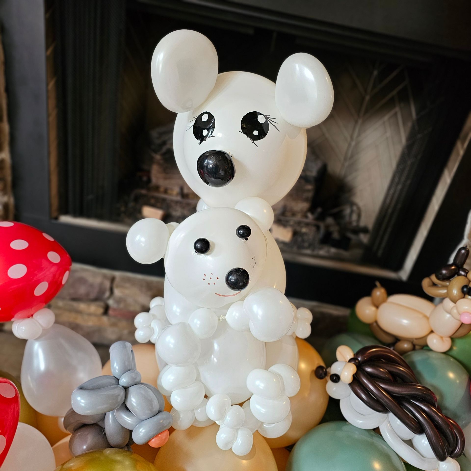 Balloon animals: bear and seal atop balloons, with mushroom, bunny, and hedgehog.