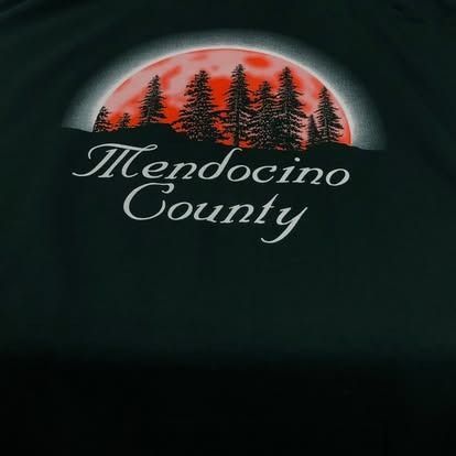 Mendocino County graphic with red moon behind silhouetted trees.