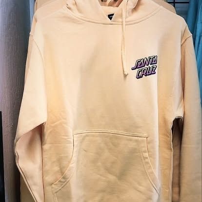 Beige Santa Cruz hoodie with a front pocket and logo.