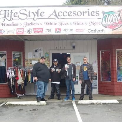 Four people standing in front of a clothing store called 