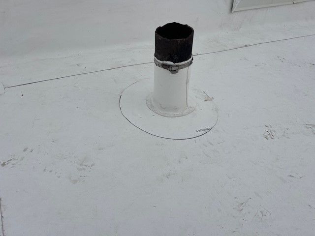 White flat roof with a vent pipe extending upwards. A circular outline surrounds the base of the pipe.