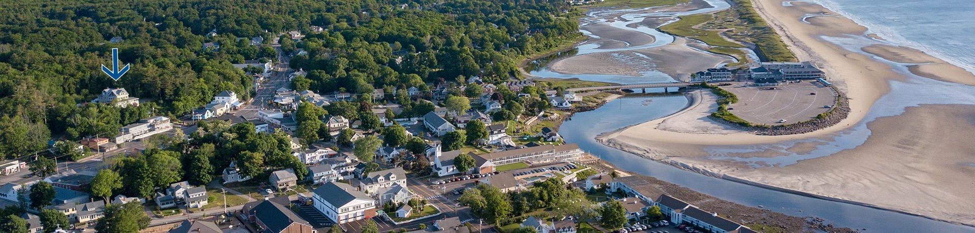An aerial view of a small town surrounded by trees and a river.