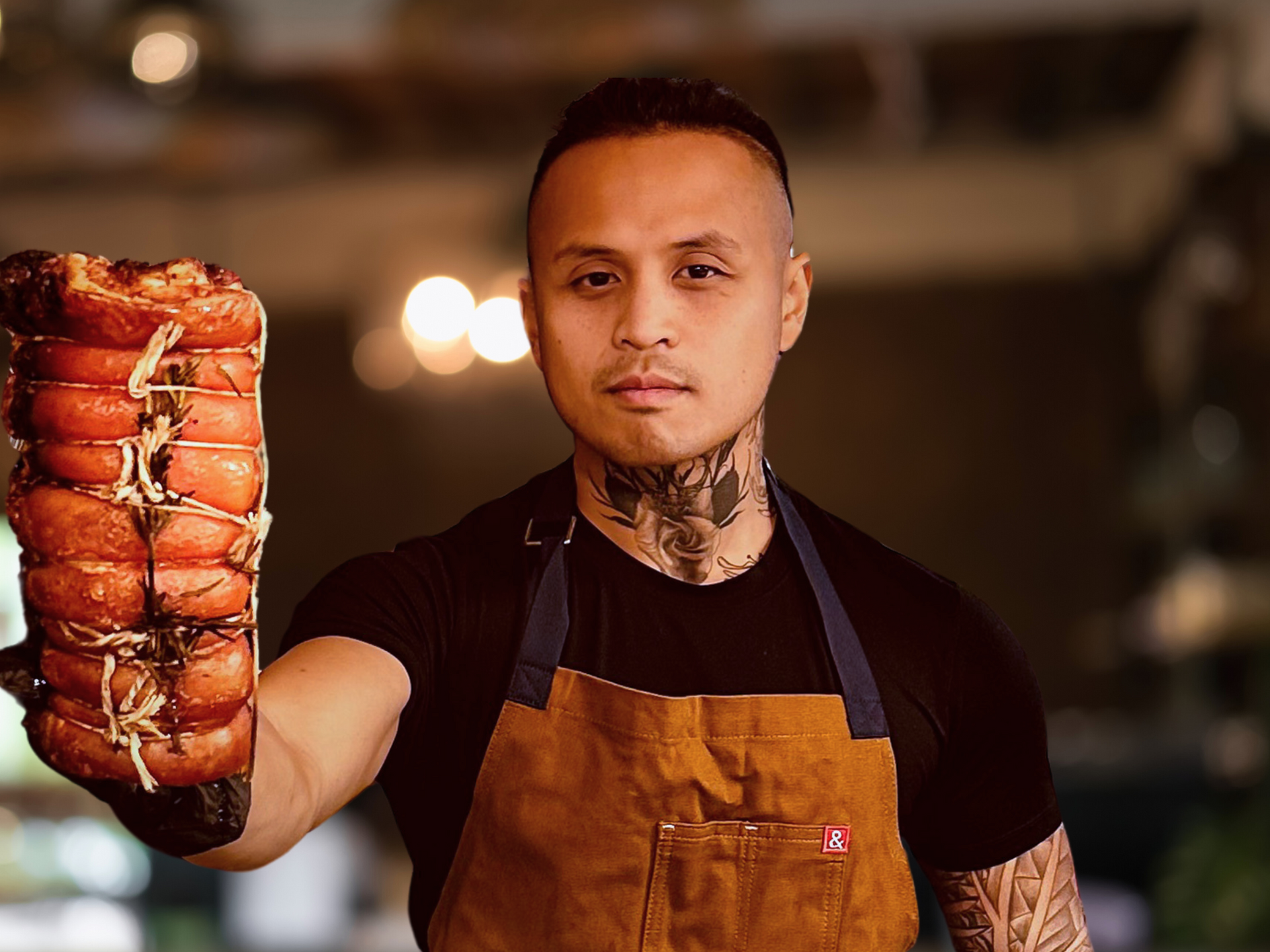 A man in an apron is holding a large piece of meat.