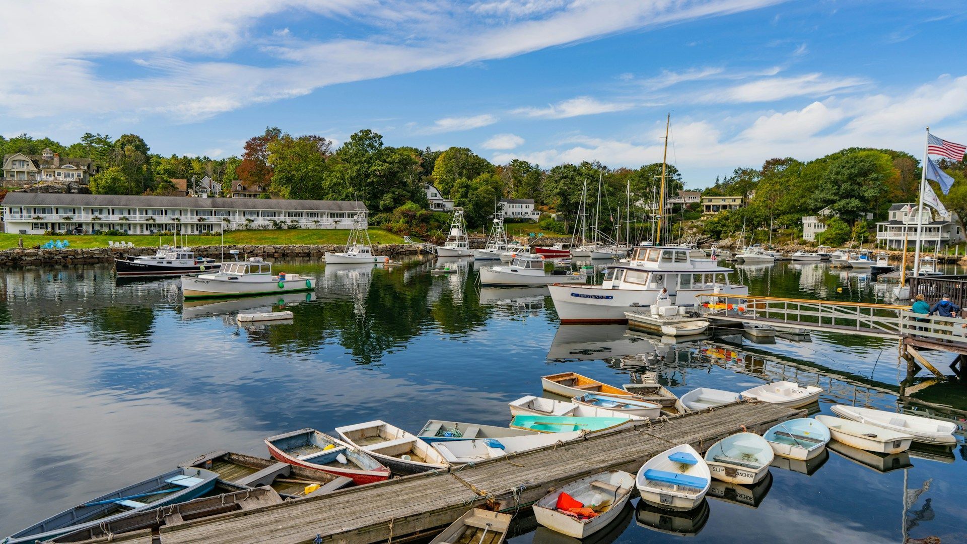 A group of boats are docked at a dock in a harbor.