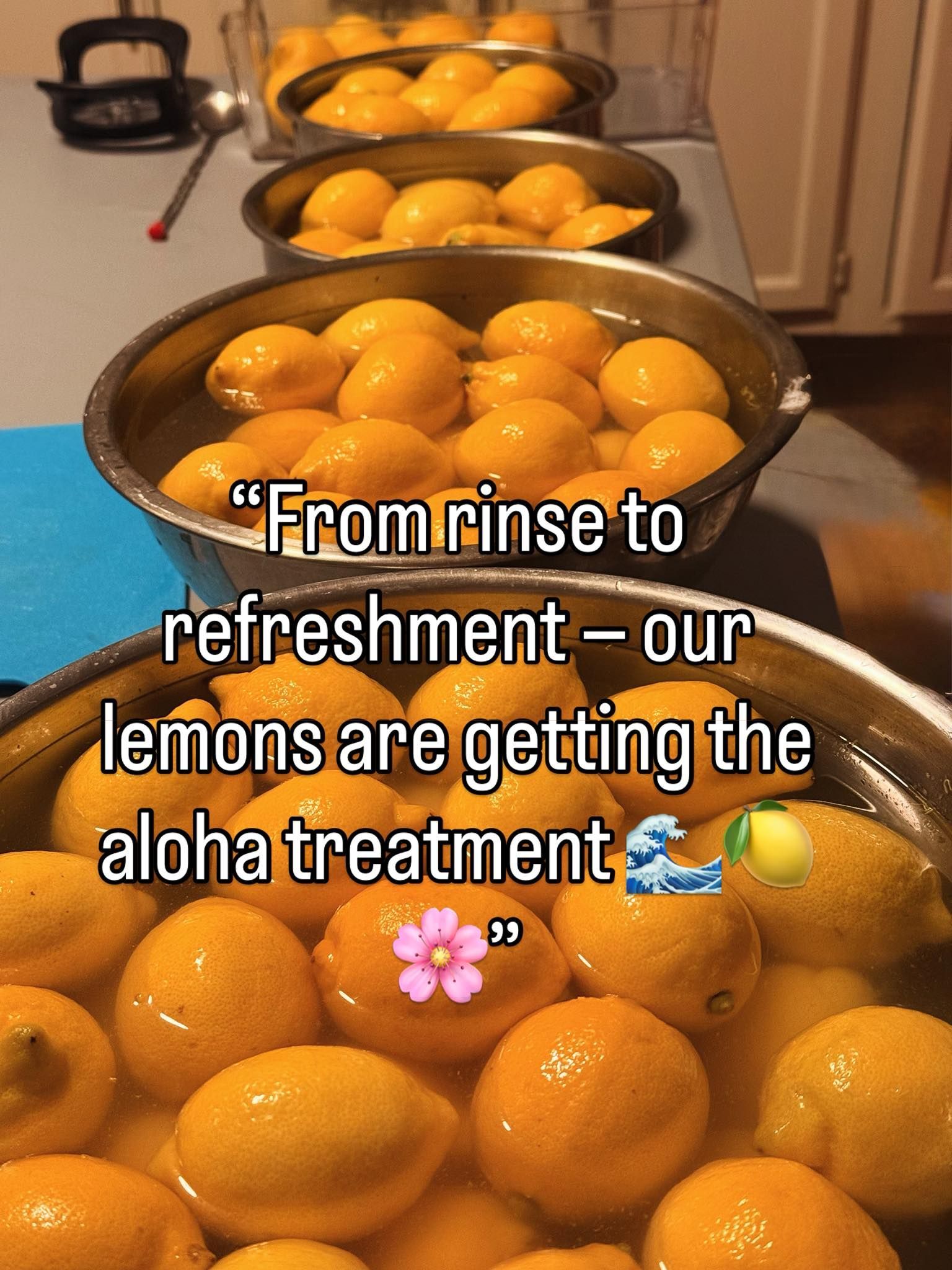 Lemons soaking in water in stainless steel bowls, with text 
