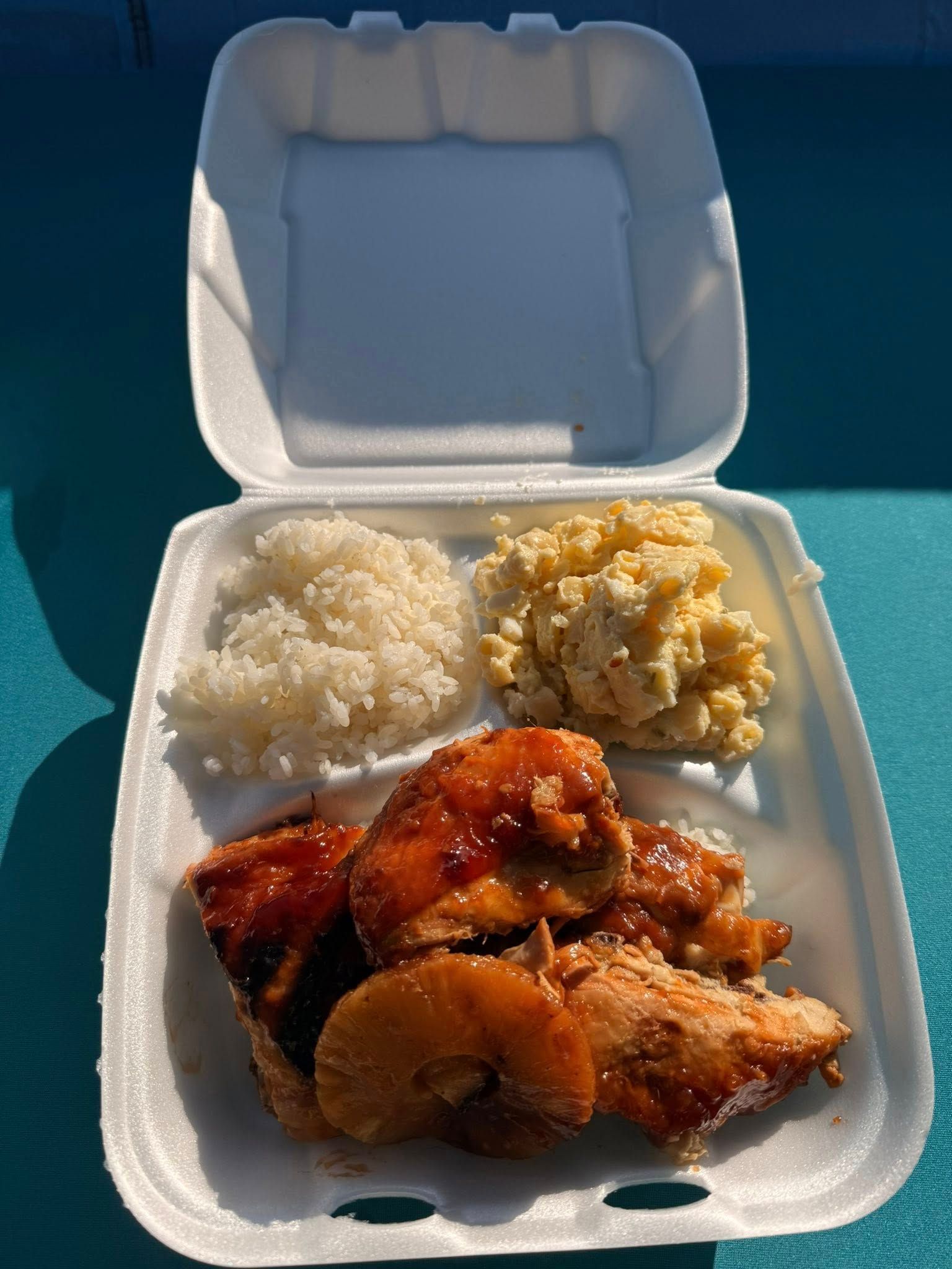 Chicken, rice, and macaroni salad in a styrofoam container, taken from an overhead perspective.
