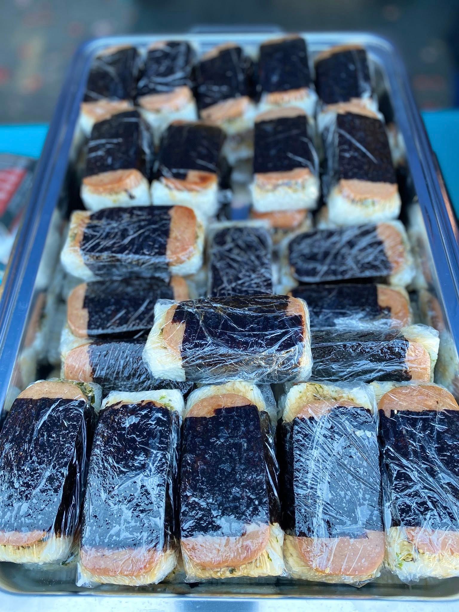 Tray of Spam musubi, wrapped in plastic, with rice and nori seaweed.
