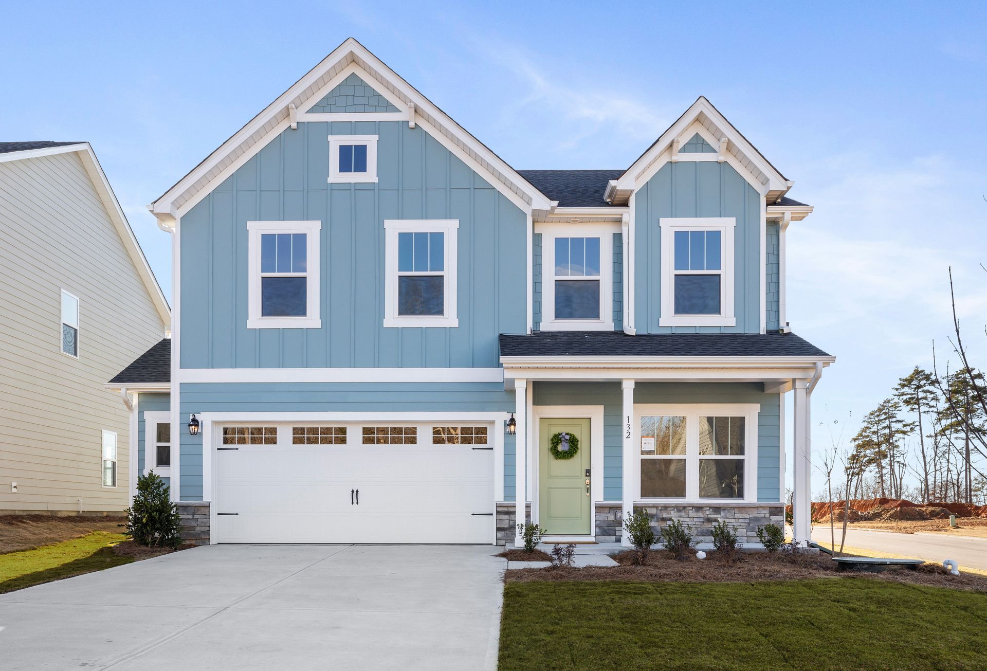 a blue house with white trim and a white garage door