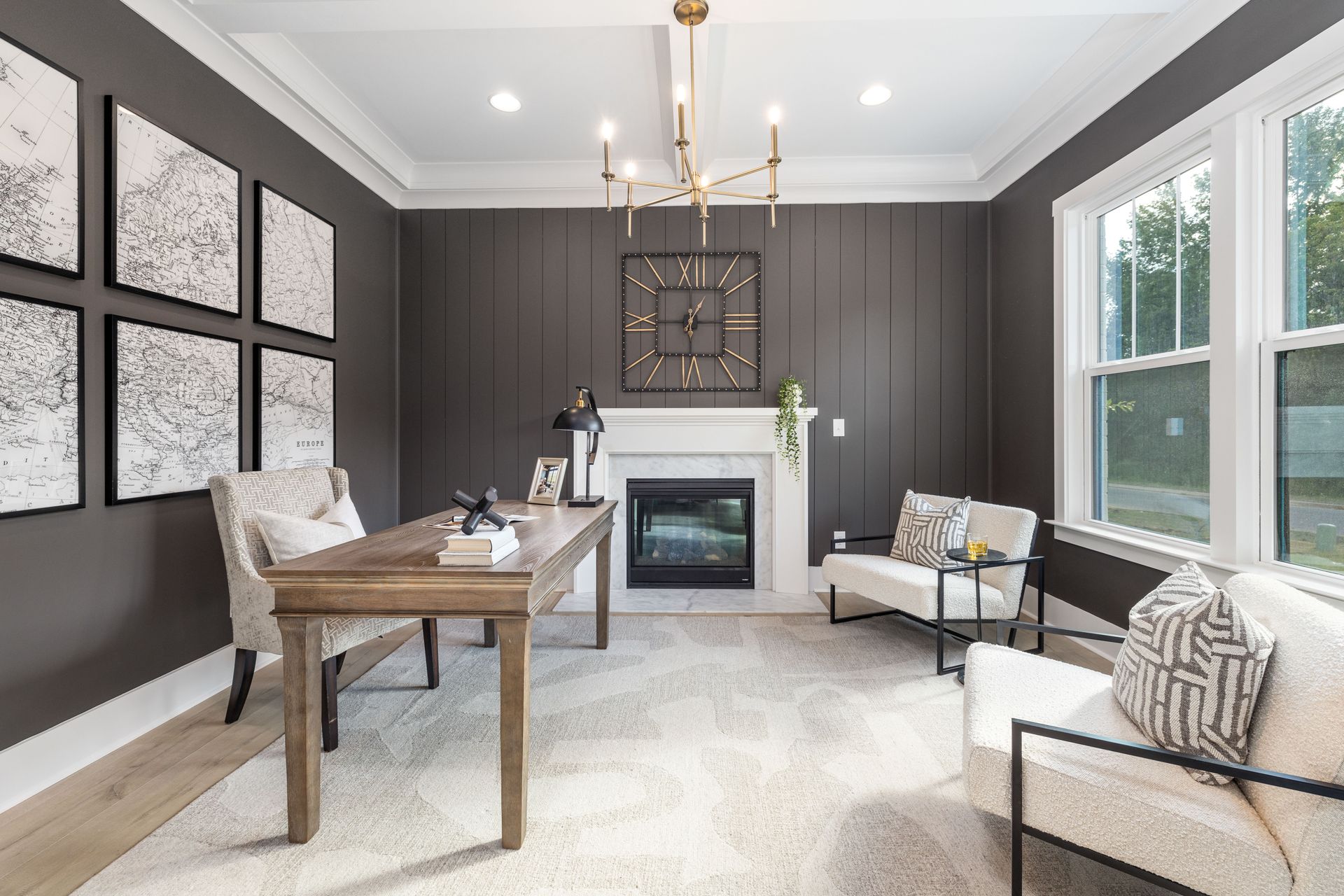 A living room with a desk , chairs , couch and fireplace.