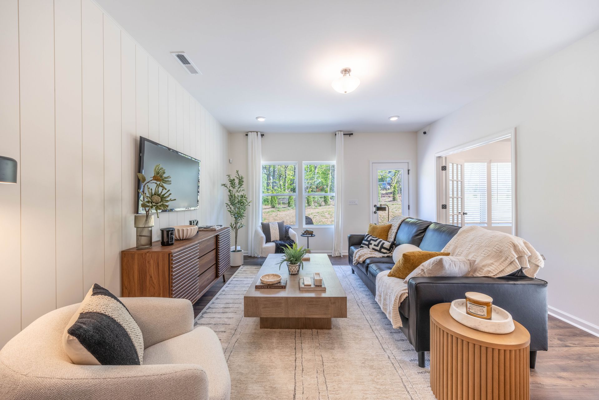 A living room with a couch , chair , coffee table and television - Abigale Floorplan by True Homes.