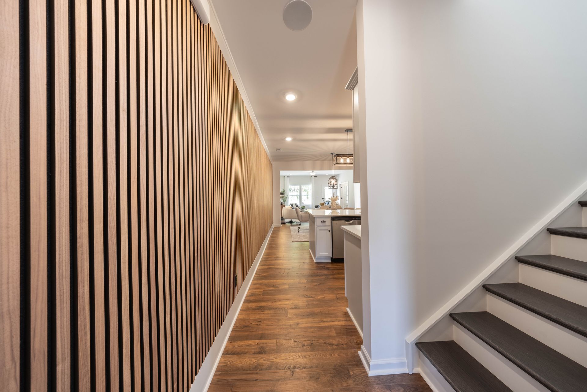 A hallway with wooden walls and stairs in a house - Abigale Floorplan by True Homes.