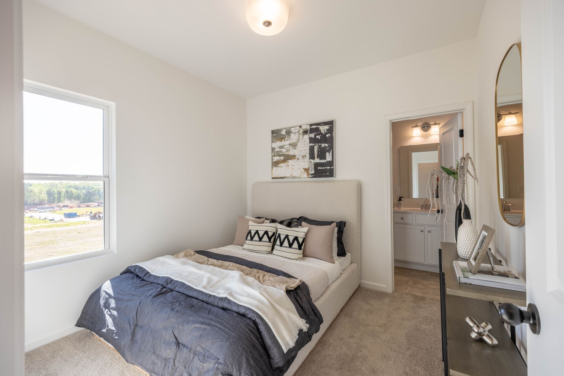 A bedroom with a bed , dresser , mirror and window - Abigale Floorplan by True Homes.