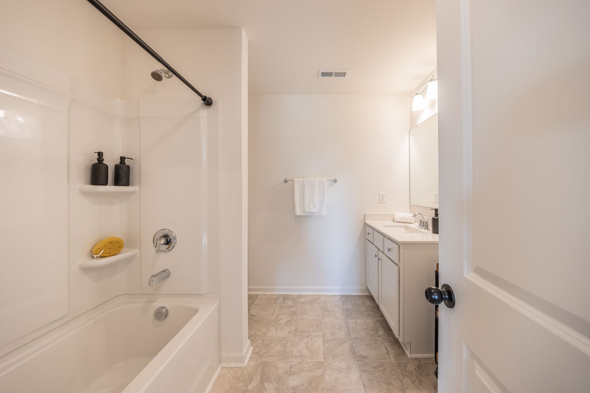 A bathroom with a tub , sink , mirror and shower - Abigale Floorplan by True Homes.
