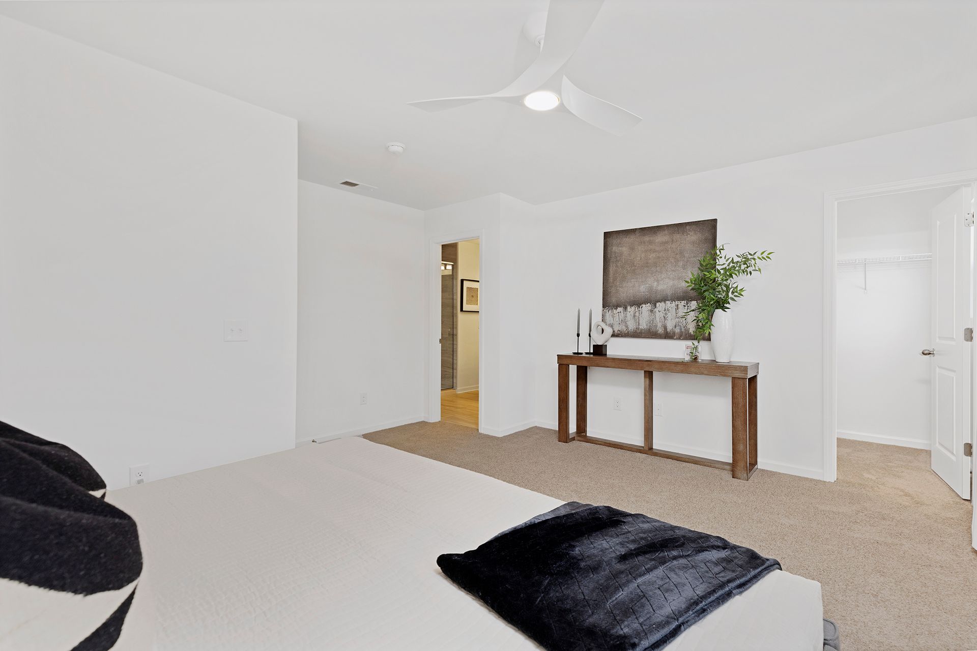 A bedroom with a bed and a ceiling fan.
