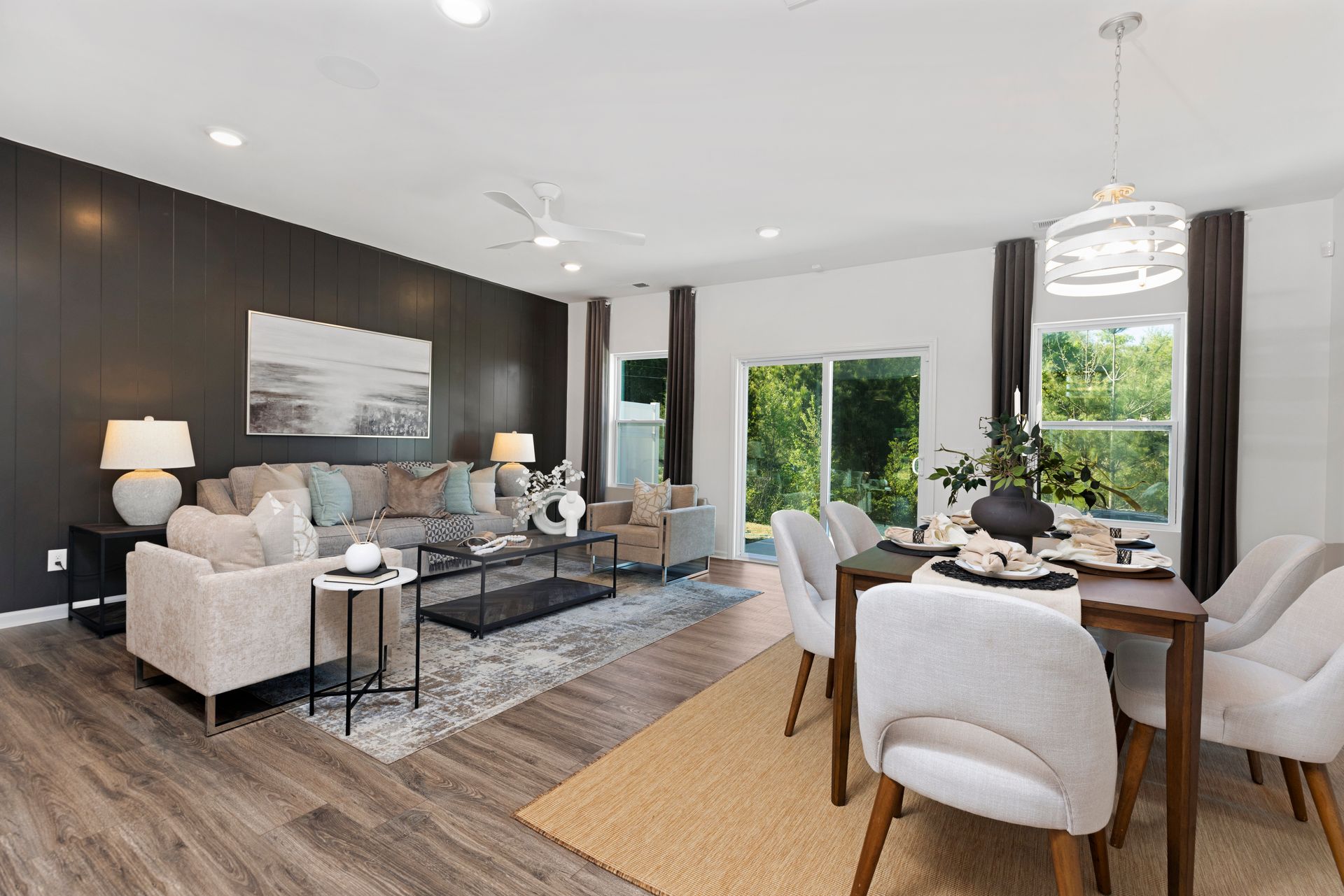 A living room and dining room in a house with a table and chairs.