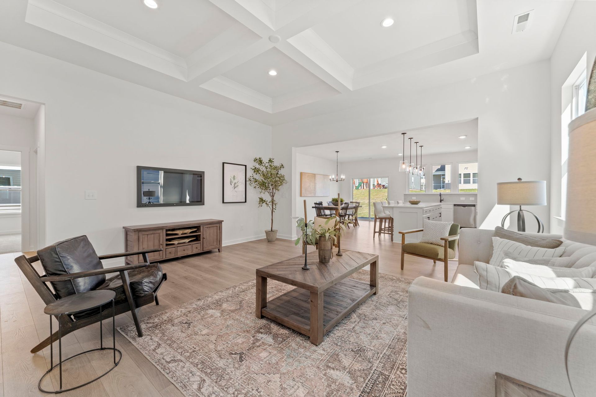 A living room with a couch , chairs , coffee table and television.