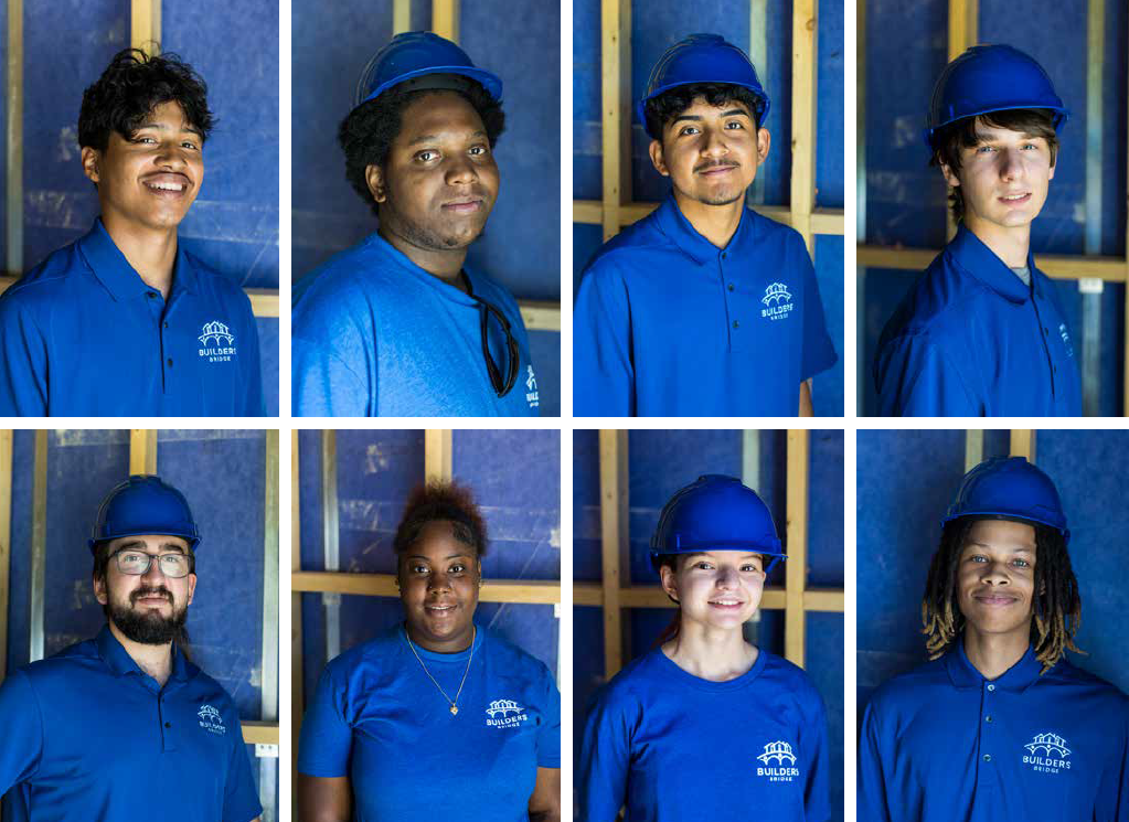 A group of people wearing blue shirts and hard hats are posing for a picture.