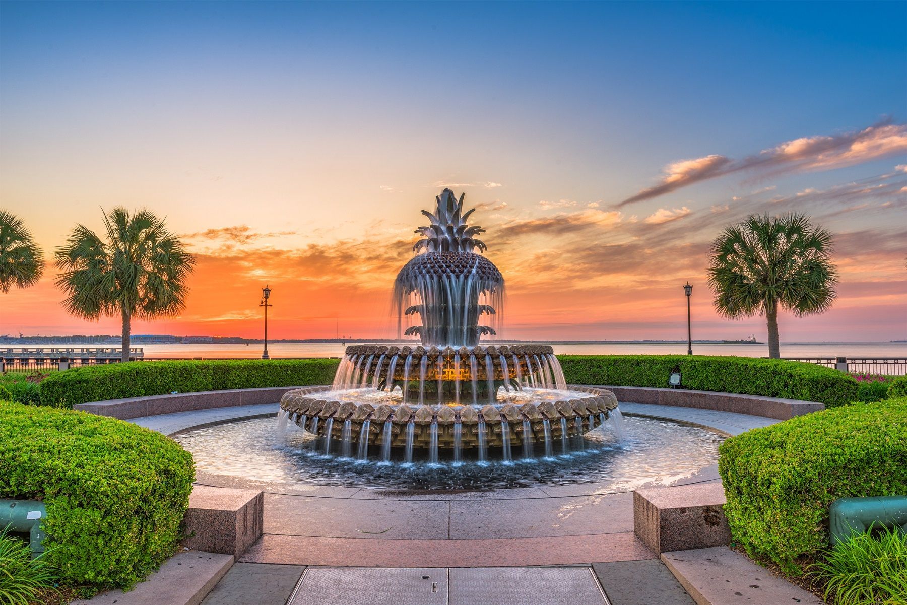 Fountain with pineapple top, water cascading, set at sunrise over Charleston waterfront.
