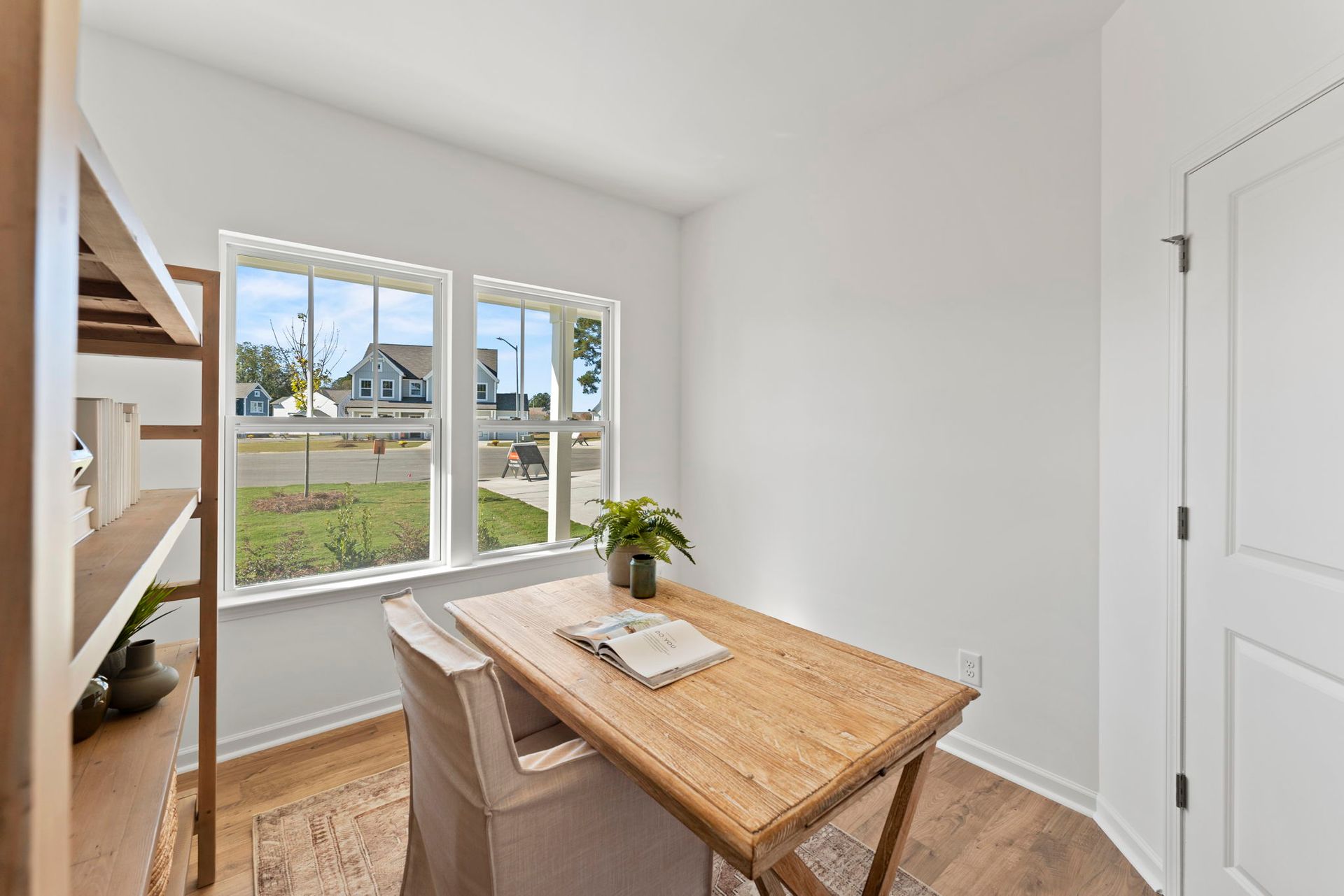 A room with a wooden table and chairs and a window.
