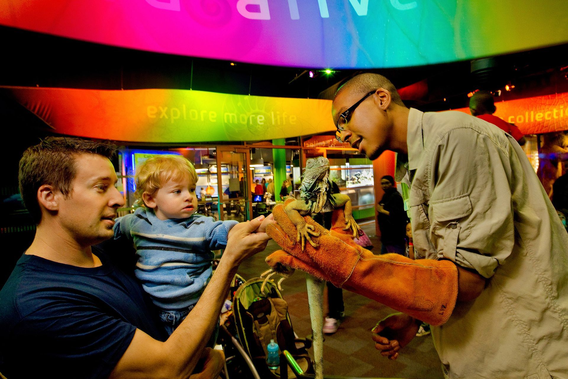 A man is petting a small child in a museum